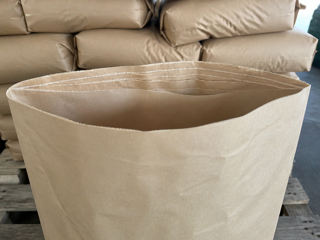 Couches de papier superposées visibles à l'ouverture d'un sac kraft multicouche